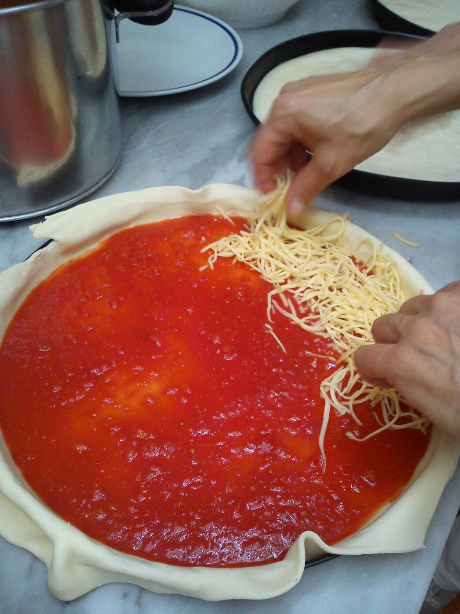 La preparazione della pizza sfogliata con pomodoro e Gouda